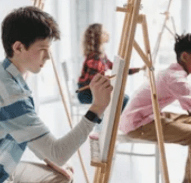 A group of young people painting on easels.