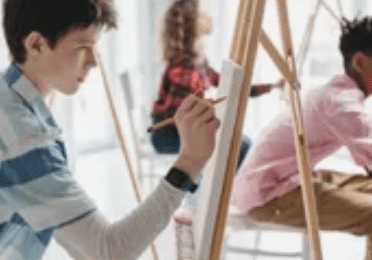 A group of young people painting on easels.